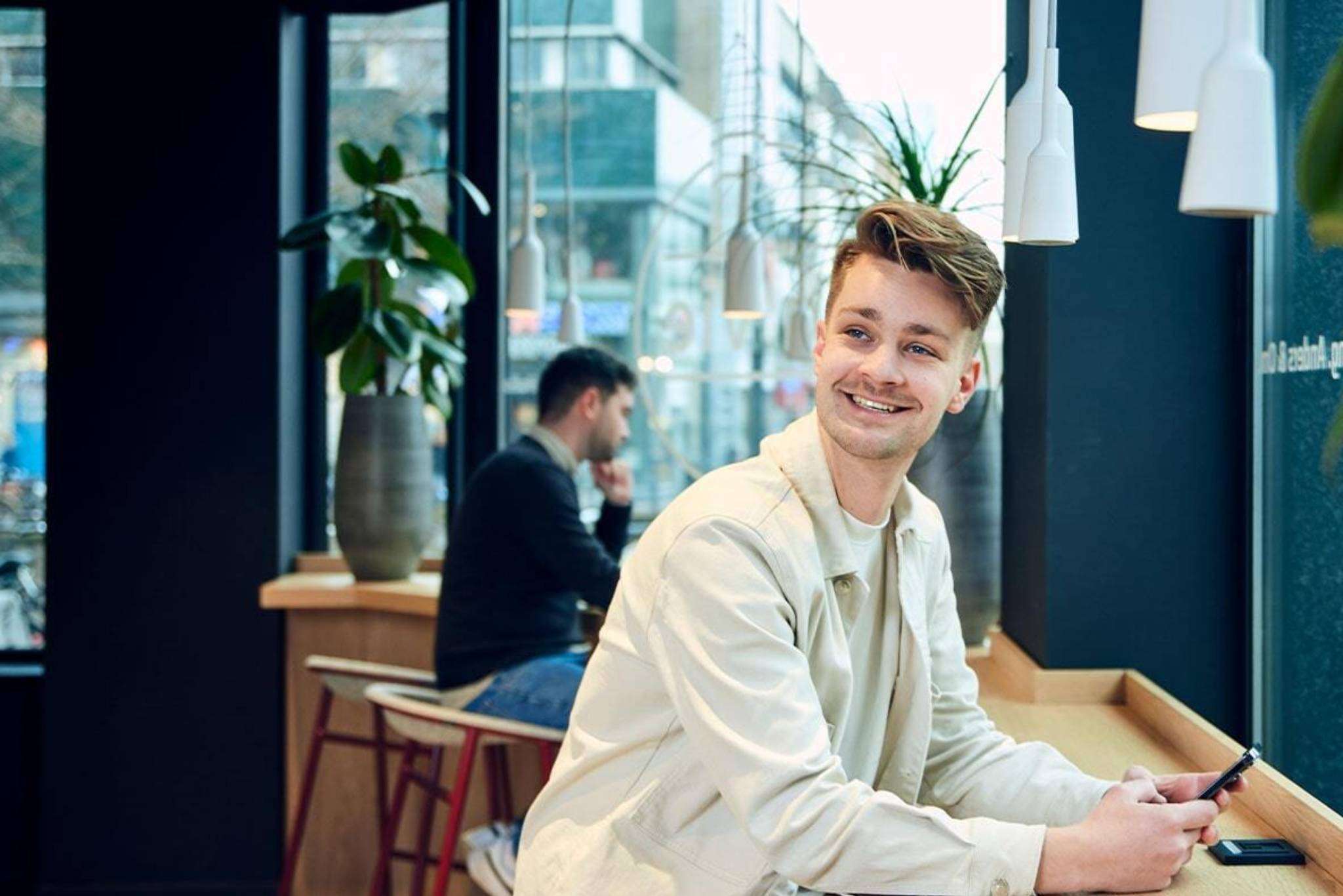 Smiling man looks aside while sitting in office.