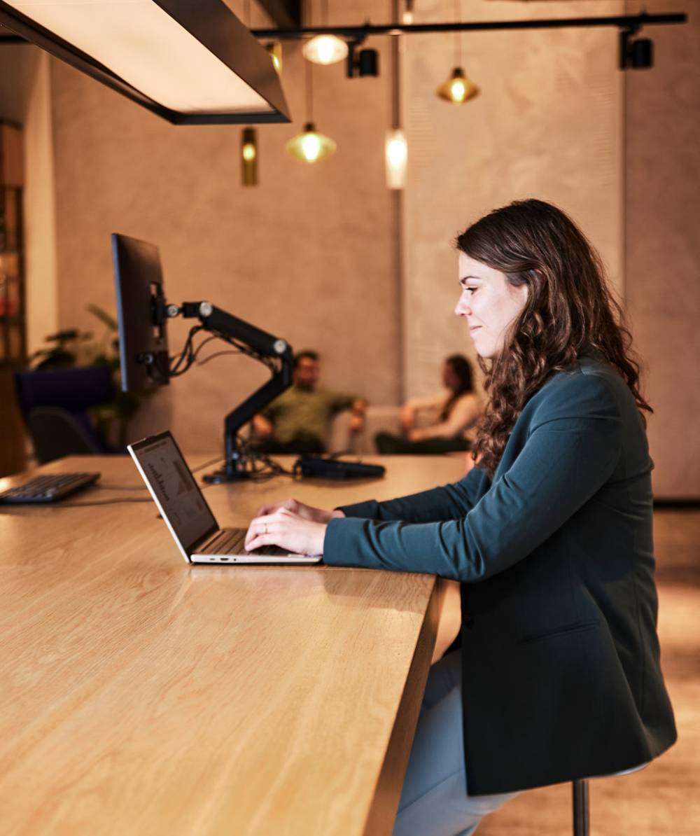 Werkende vrouw achter laptop.