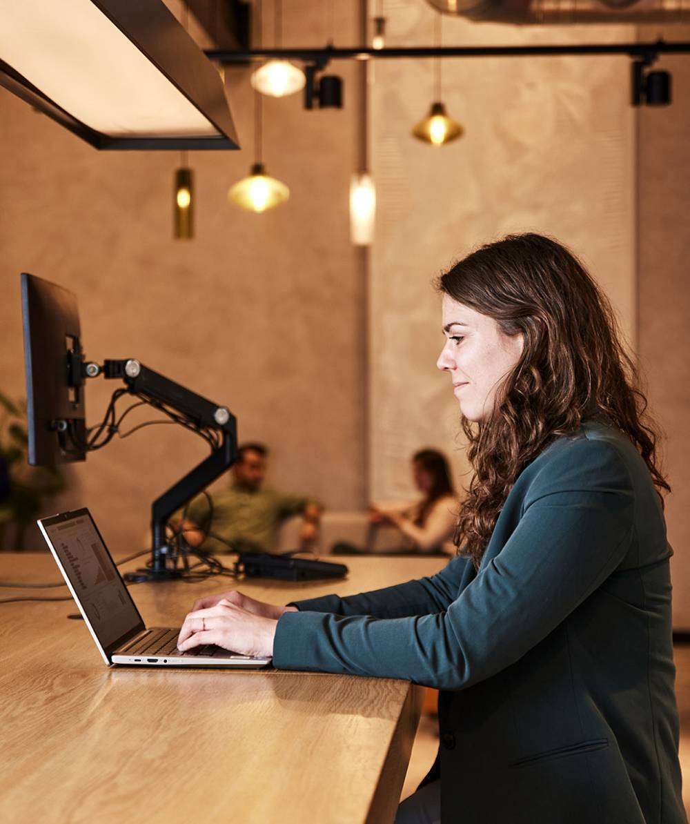 Woman behind laptop in office.